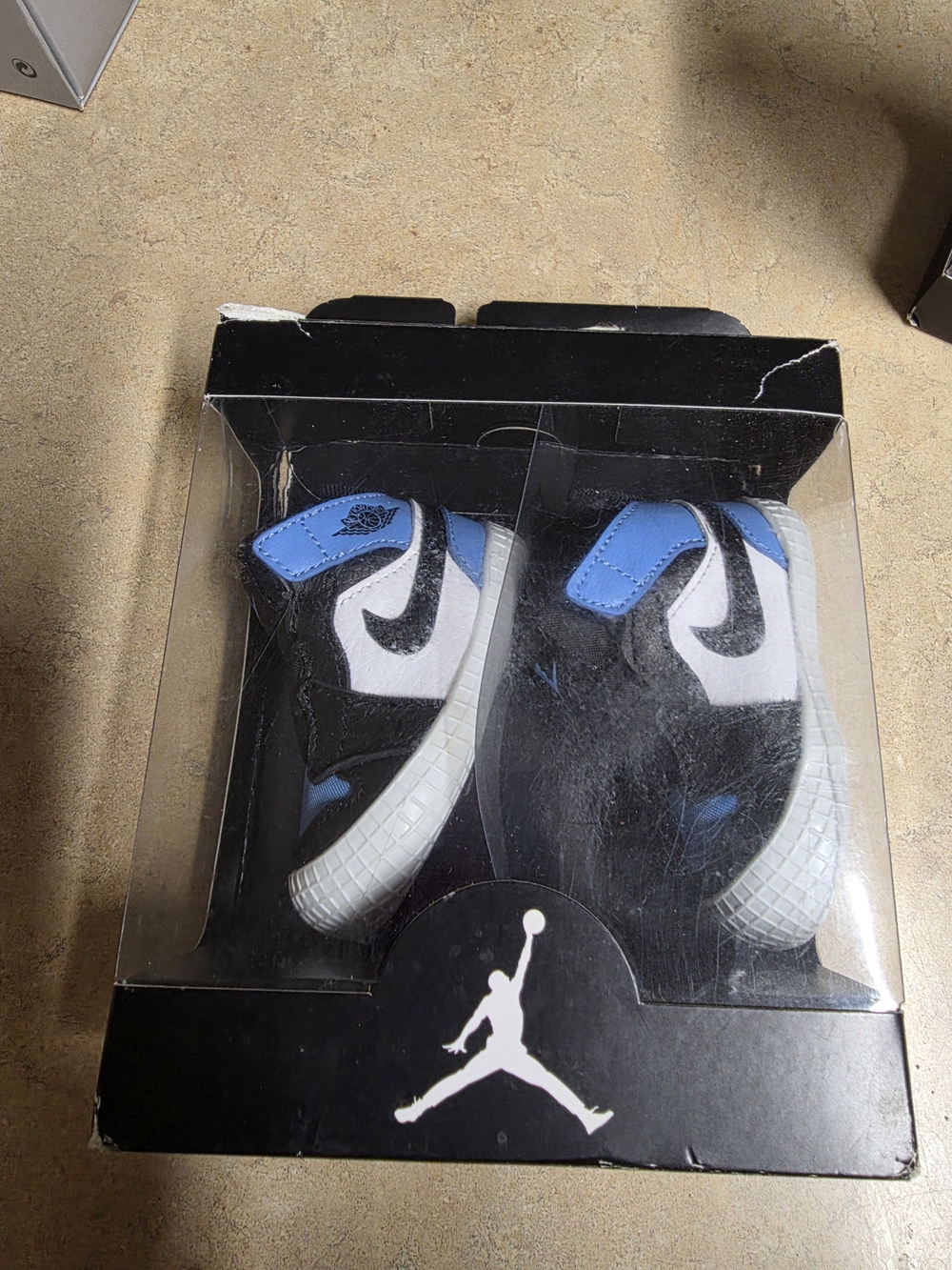 Jordan 1 Crib Bootie in Black, White & University Blue